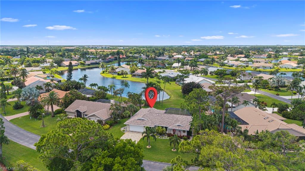 Spacious property featuring a tiled roof and an attached garage, surrounded by mature landscaping and a well-maintained lawn