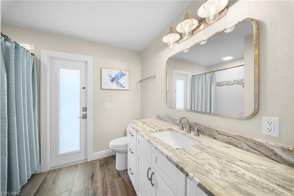 Bathroom vanity with a rectangular undermount sink, brushed nickel faucet, and natural stone countertop