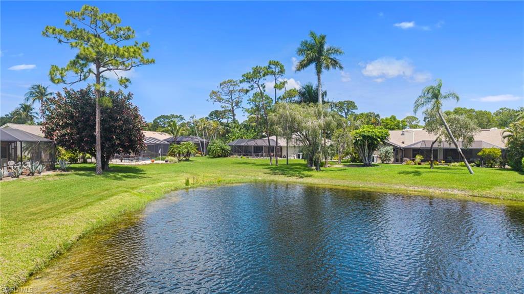 Lakeside property featuring expansive green space and mature tropical landscaping