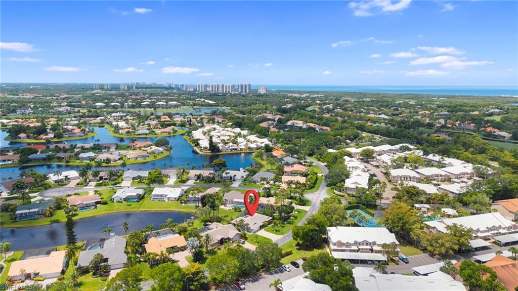 Aerial perspective showcasing a residential community with water features and distant city skyline
