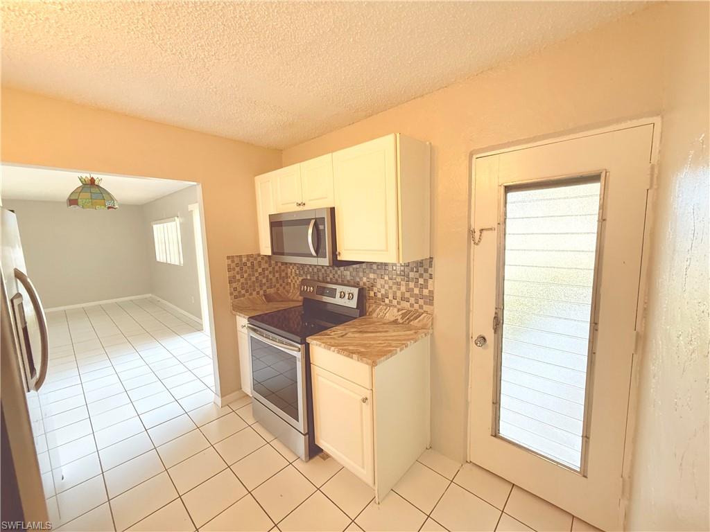 Kitchen with tile flooring and a patterned backsplash