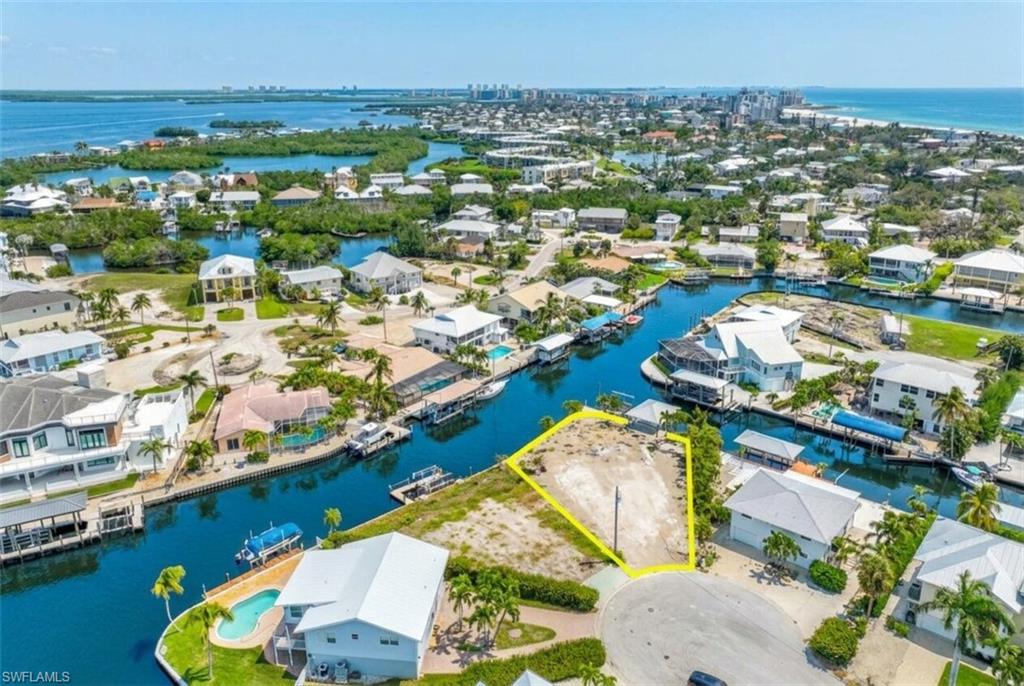 Vacant cul-de-sac lot featuring waterfrontage on a canal with direct Gulf access, surrounded by residential properties, and proximity to the Gulf of Mexico - Virtually Edited Image