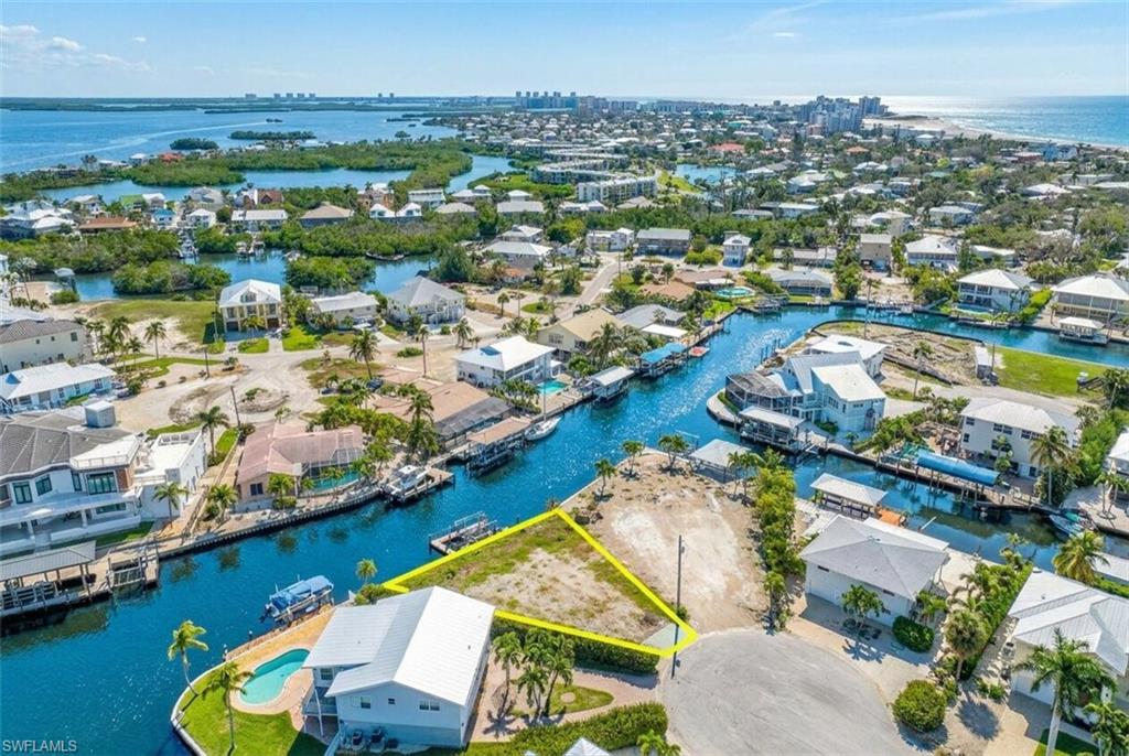 Waterfront lot featuring direct canal access, a cul-de-sac location, and surrounding residential properties - Virtually Edited Image