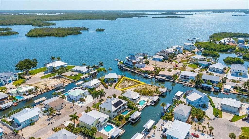 Waterfront property with direct canal access, featuring a clear building lot and proximity to open water - Virtually Edited Image