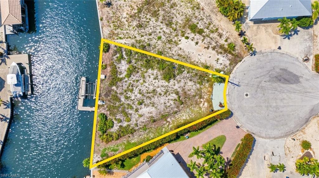 Waterfront lot featuring a private boat lift and direct canal access - Virtually Edited Image
