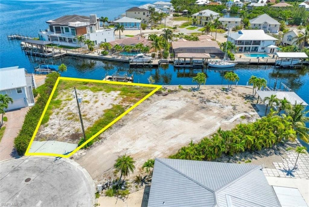 Waterfront lot featuring direct canal access, a cul-de-sac location, and existing vegetation - Virtually Edited Image