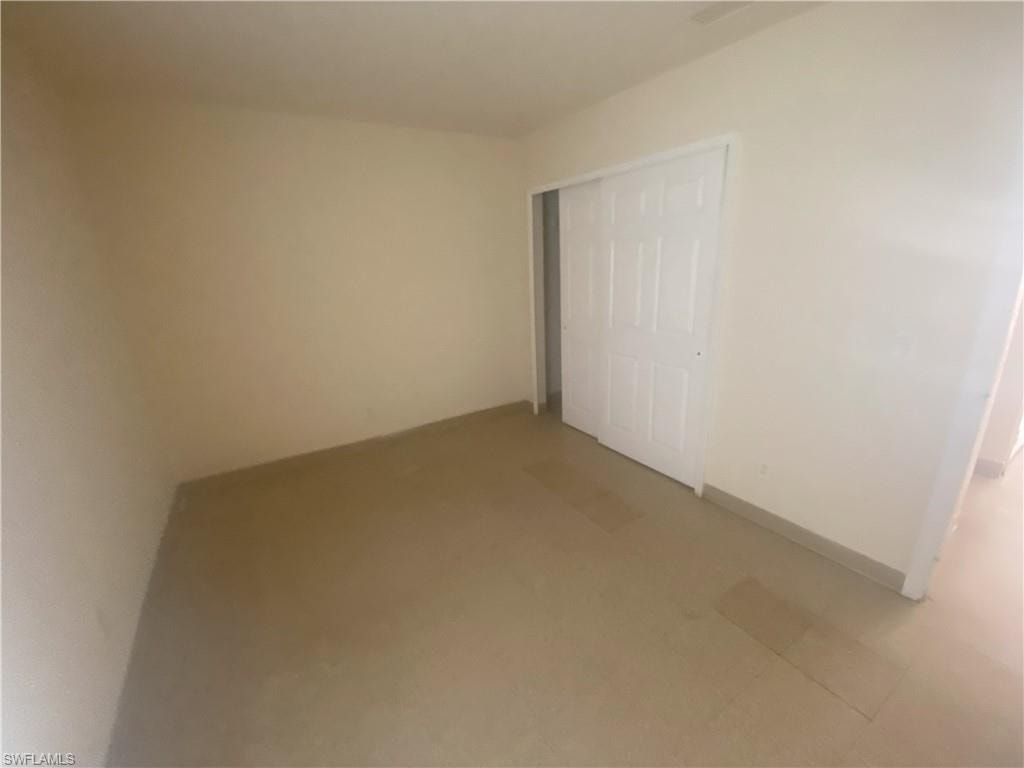 Room featuring neutral-toned walls, tile flooring, and a white bi-fold closet door
