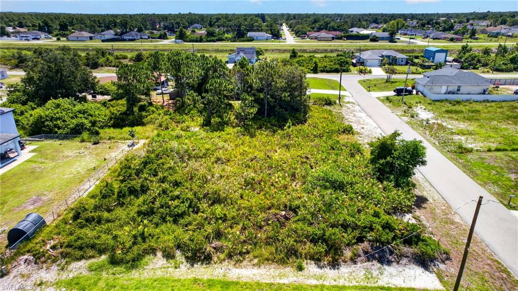Expansive undeveloped lot featuring mature vegetation and established perimeter fencing