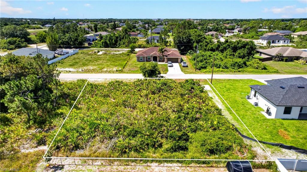Expansive vacant land parcel featuring dense vegetation and defined lot lines