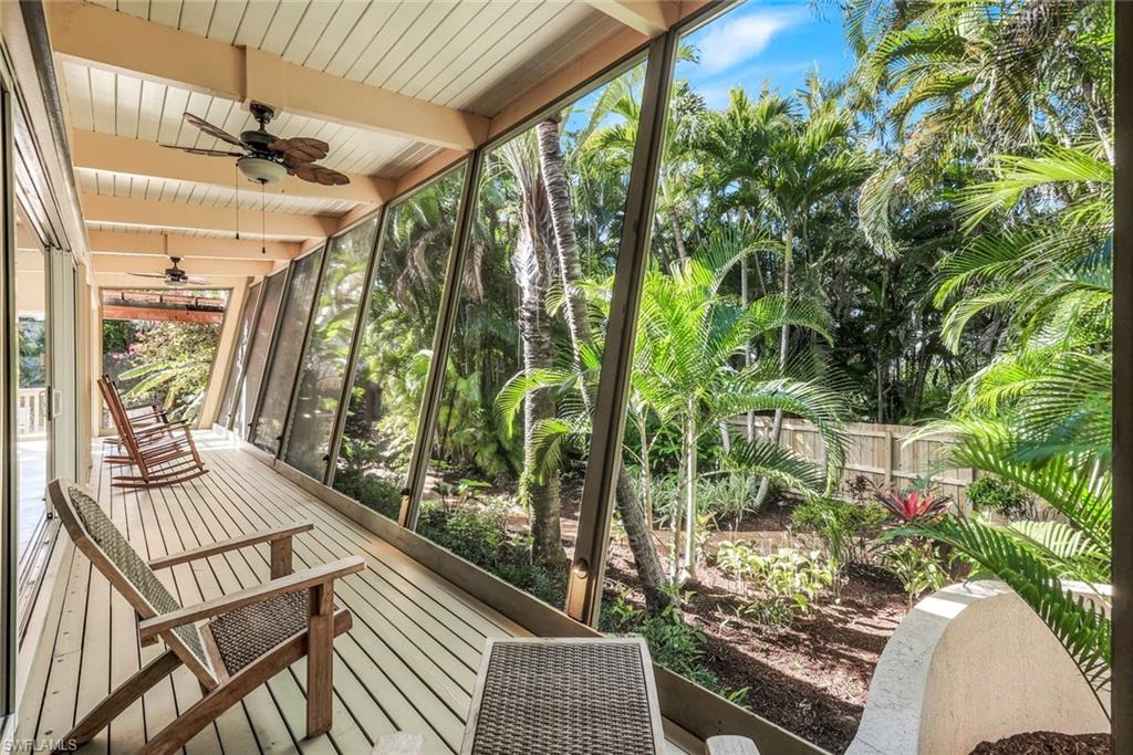 Screened in sunroom featuring ceiling fans andbeam ceiling