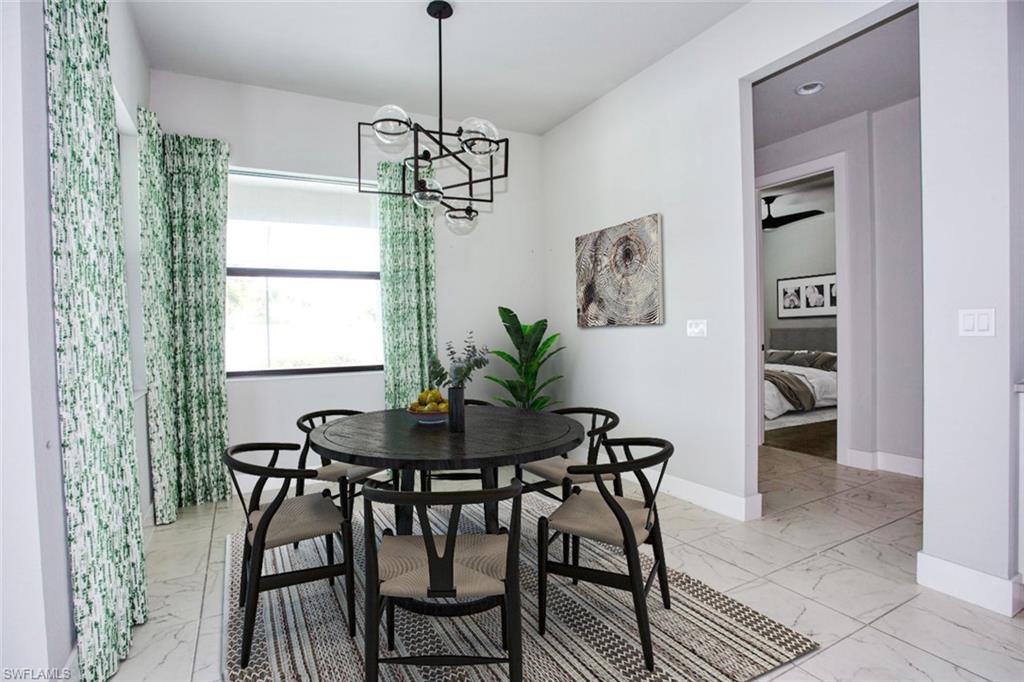 Spacious dining area featuring large format tile flooring, a contemporary chandelier, and a wide window