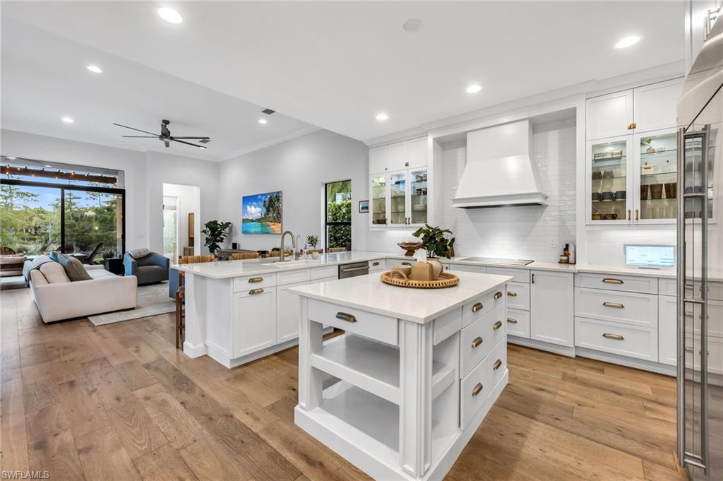 Modern kitchen featuring white cabinetry, a large kitchen island, and wood-finish flooring