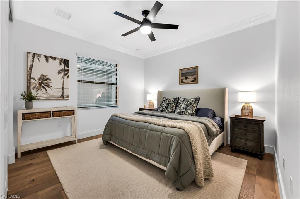 Bedroom featuring wood-finish flooring, crown molding, and a ceiling fan with integrated lighting
