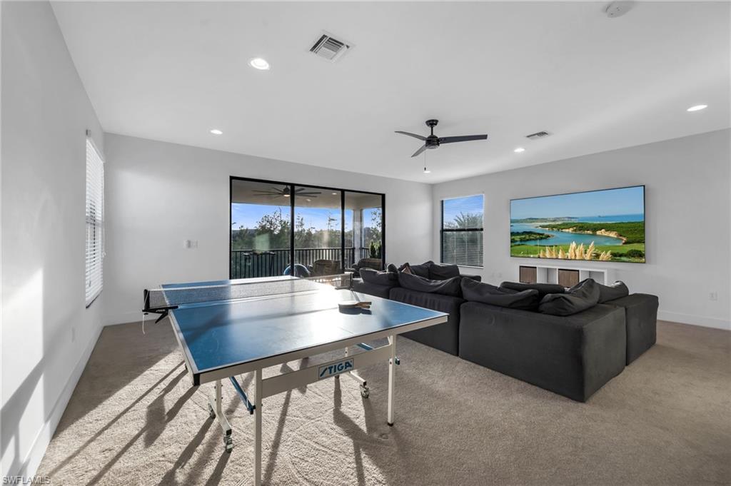 Carpeted room featuring a ceiling fan, recessed lighting, and expansive sliding glass doors opening to a balcony
