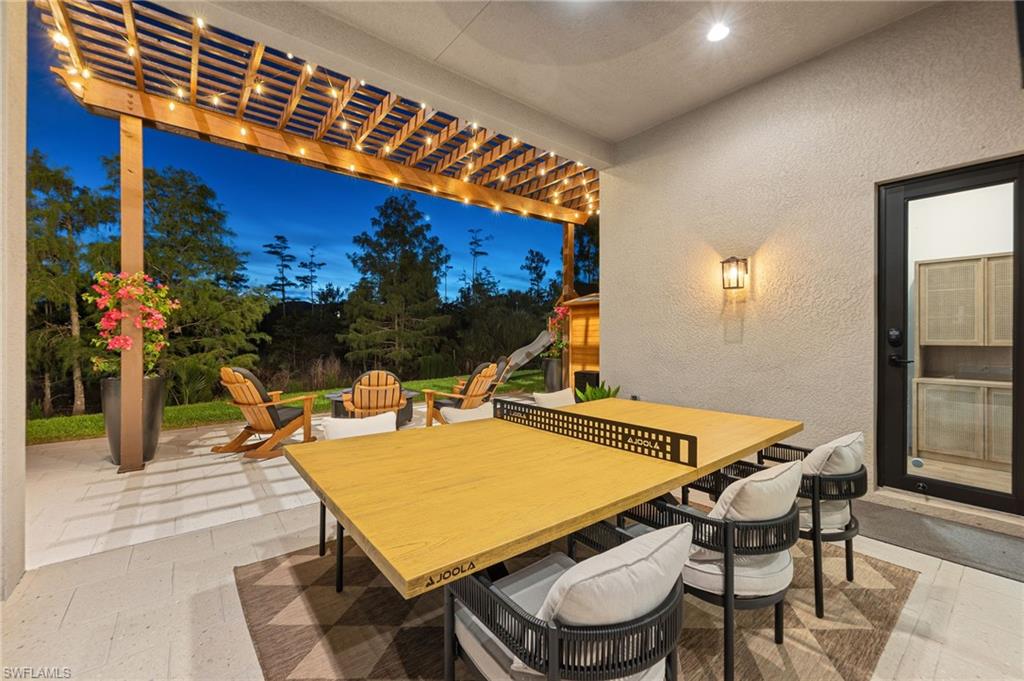 Covered outdoor patio with a wood pergola featuring string lighting