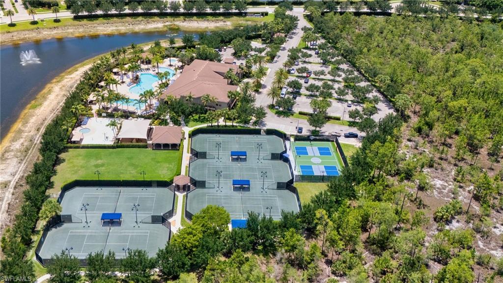 Expansive recreational grounds featuring multiple tennis courts, pickleball courts, and a large swimming pool complex