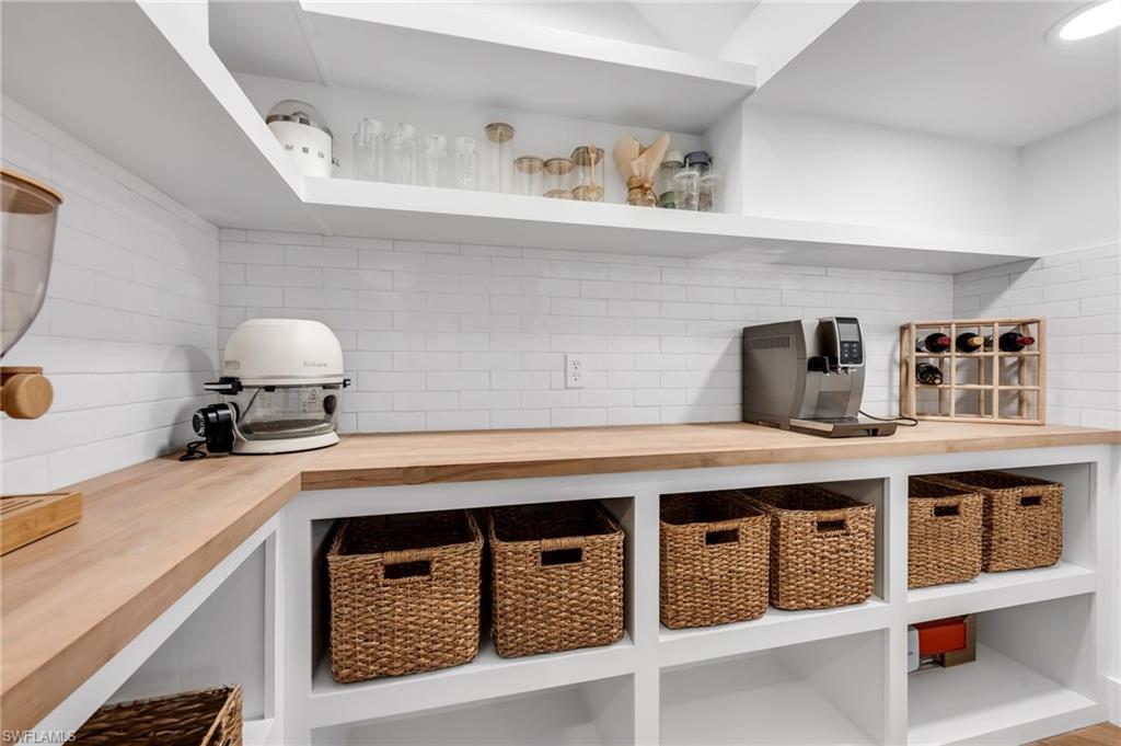 Extensive wood-finish countertops with white subway tile backsplash