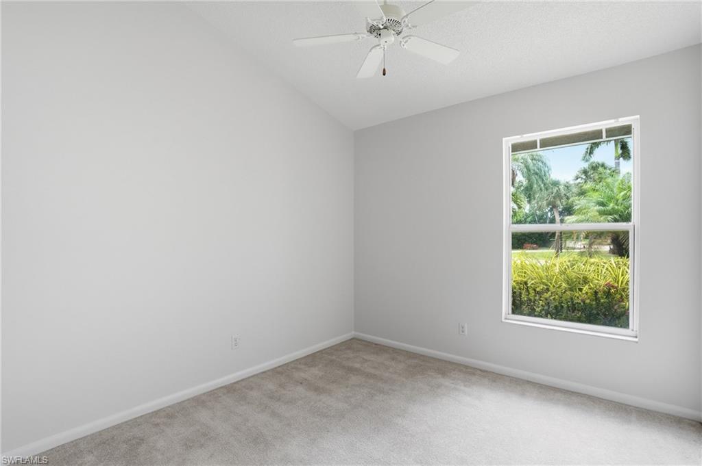 Bedroom 3 Carpeted room featuring a vaulted ceiling with a ceiling fan, a window with exterior landscaping, and light gray wall paint