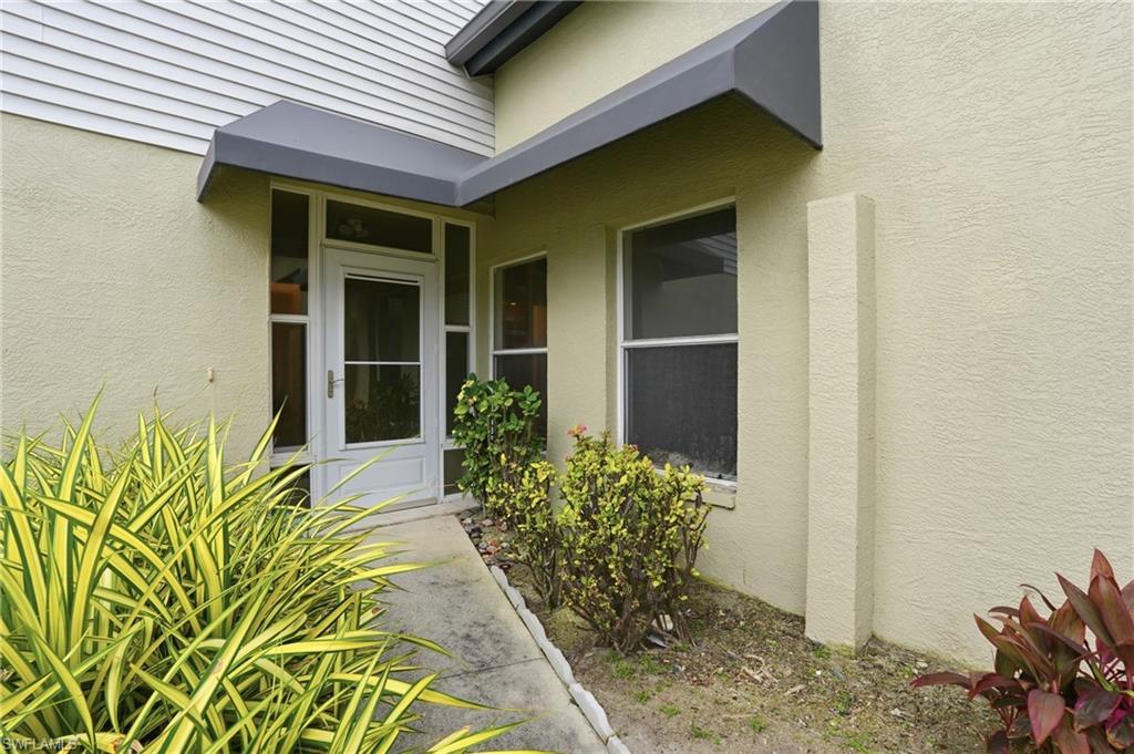 White entry door with sidelights, transom window, and overhead awning