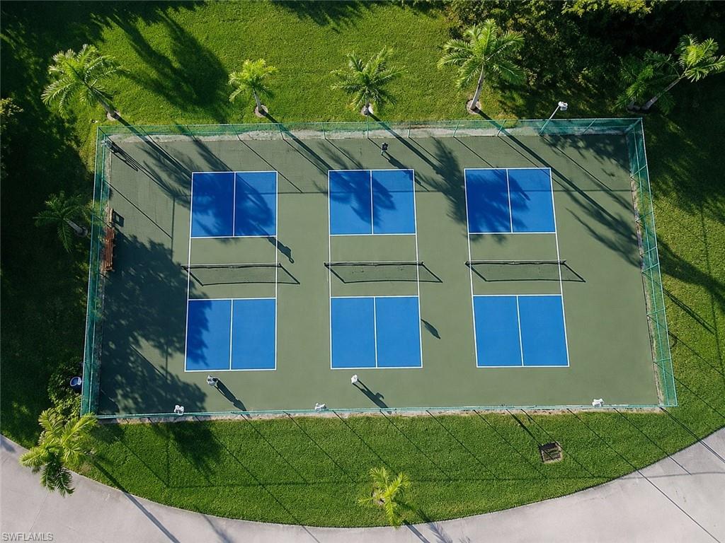Three regulation-sized pickleball courts with blue playing areas on a green surface