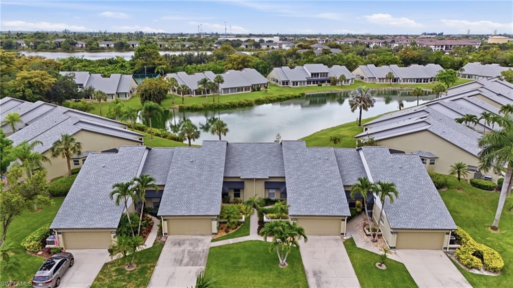 Paired townhomes featuring attached garages and private driveways, surrounded by manicured landscaping