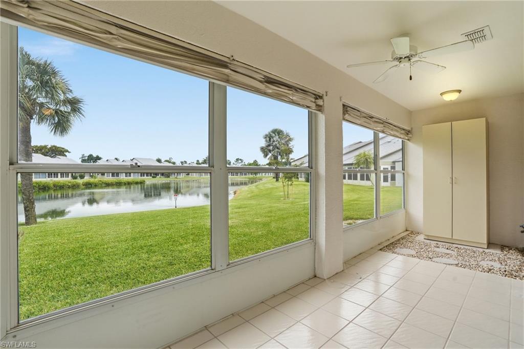 Enclosed sunroom featuring expansive windows, tile flooring, and a ceiling fan