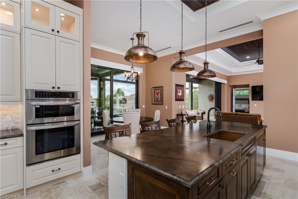 Kitchen featuring a large island with an integrated sink and industrial-style pendant lighting