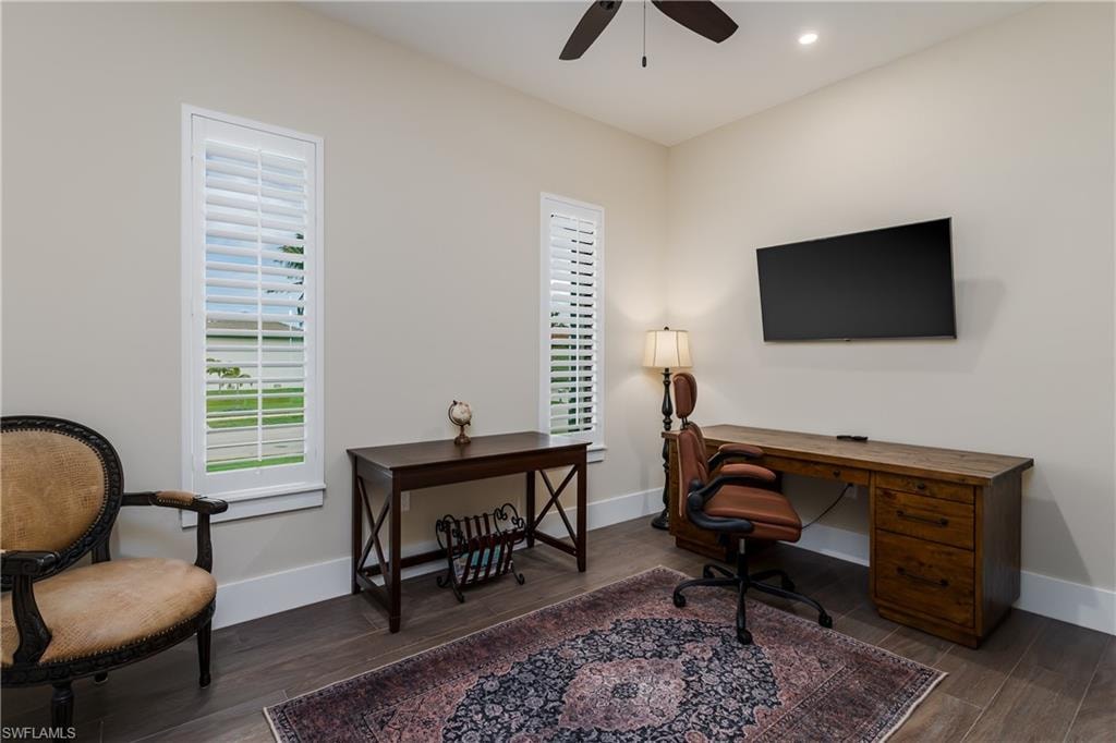 Room featuring wood-finish flooring, two windows with plantation shutters, a ceiling fan, and recessed lighting