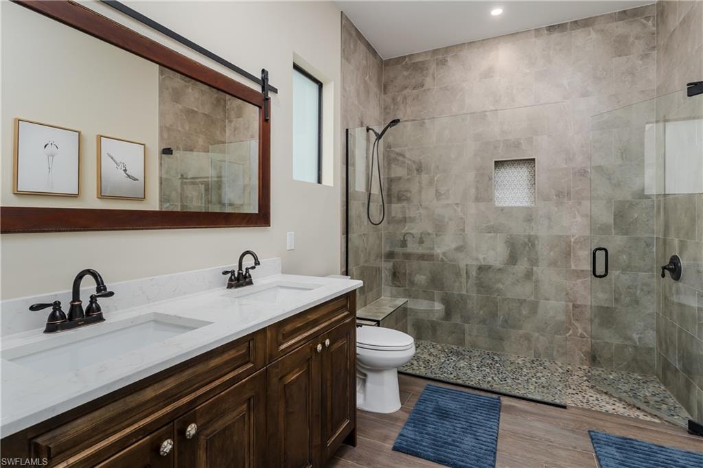 Bathroom featuring a dual vanity with wood-finish cabinetry and white countertops