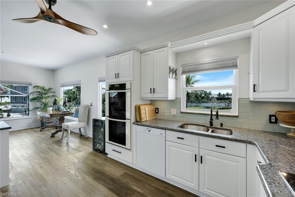 Kitchen features white shaker cabinets, high-end appliances, and water views.