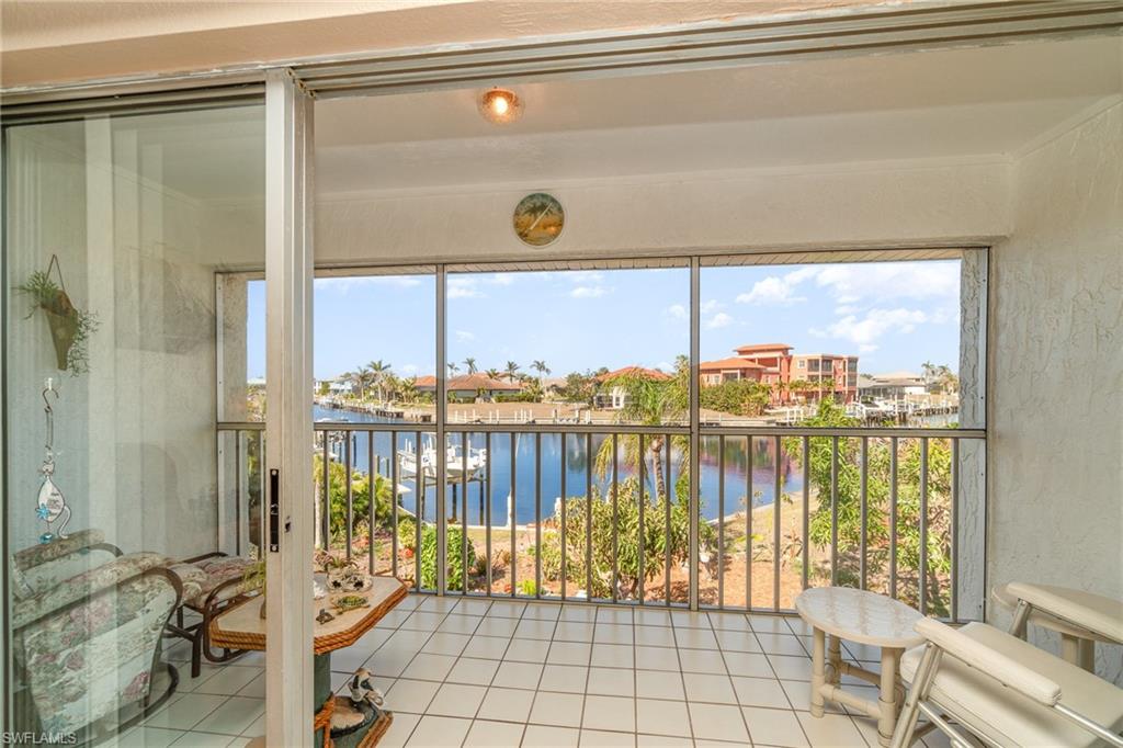 Screened balcony featuring white square tile flooring and a water vista