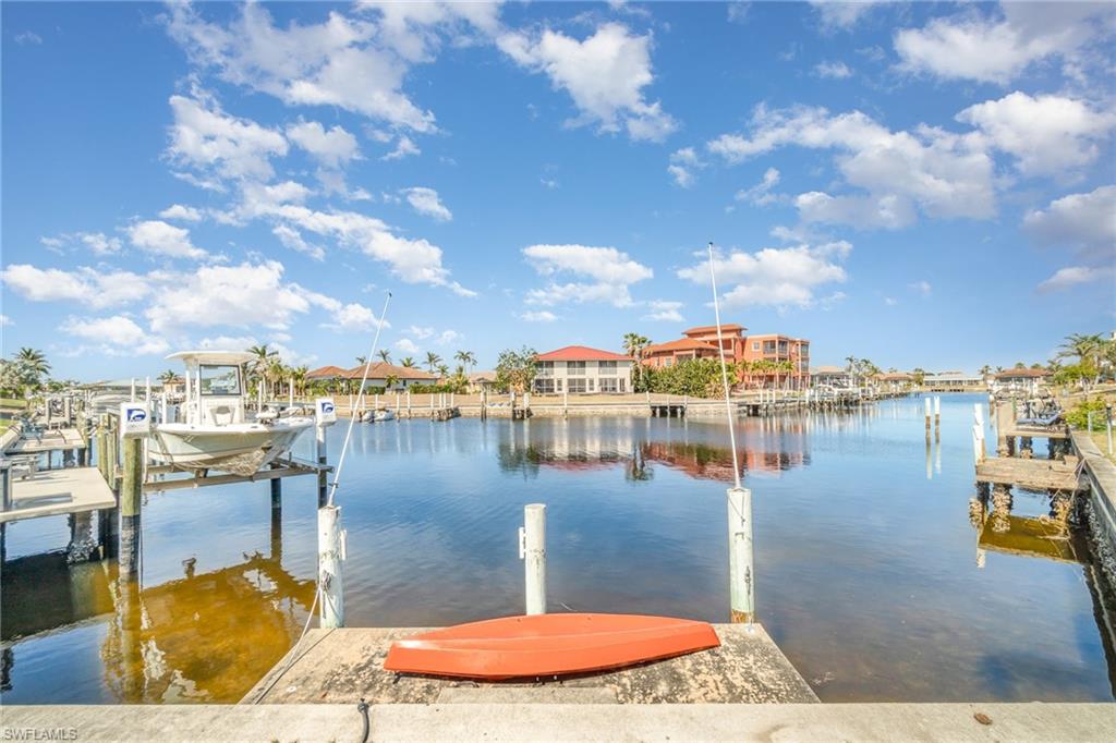 Waterfront property featuring a concrete dock, multiple boat slips, and direct canal access