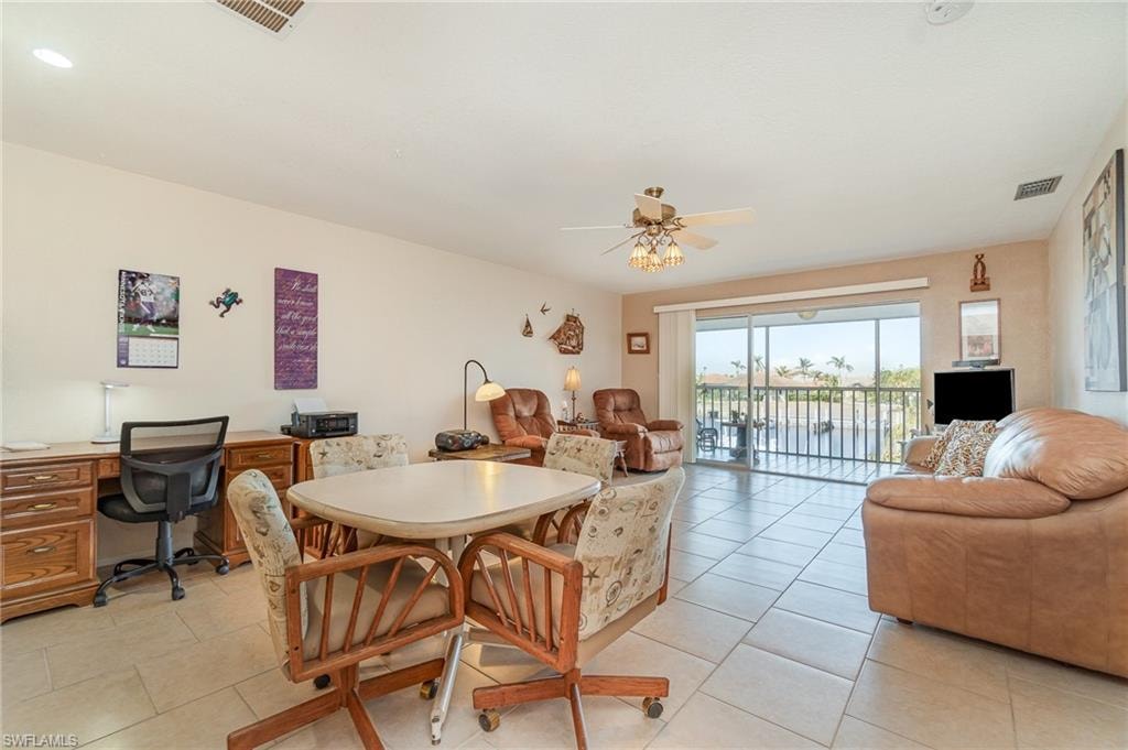 Expansive living area with large format tile flooring and a ceiling fan