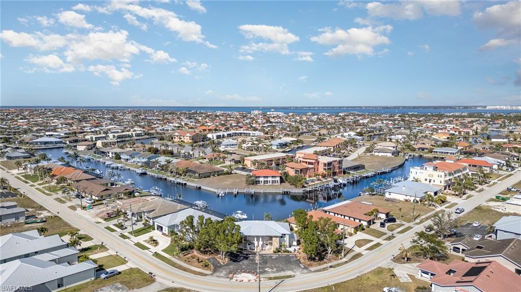 Waterfront neighborhood featuring canal access, residential streets, diverse architectural styles, and distant water bodies