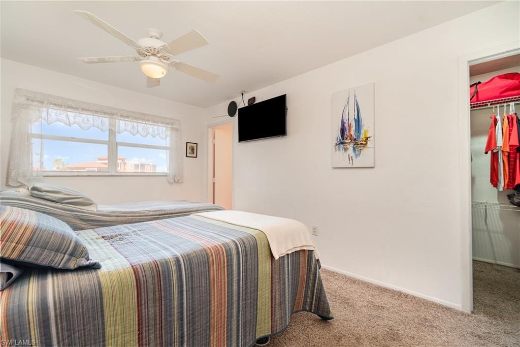 Carpeted interior space featuring white walls and a ceiling fan with integrated lighting
