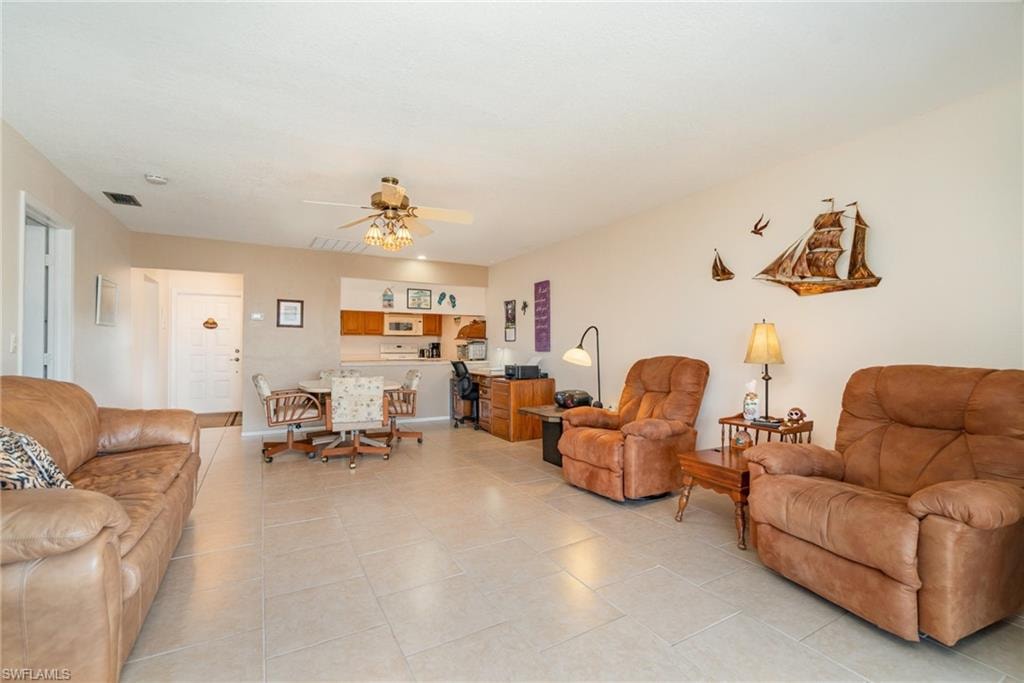 Open-concept living area featuring light-toned tile flooring throughout