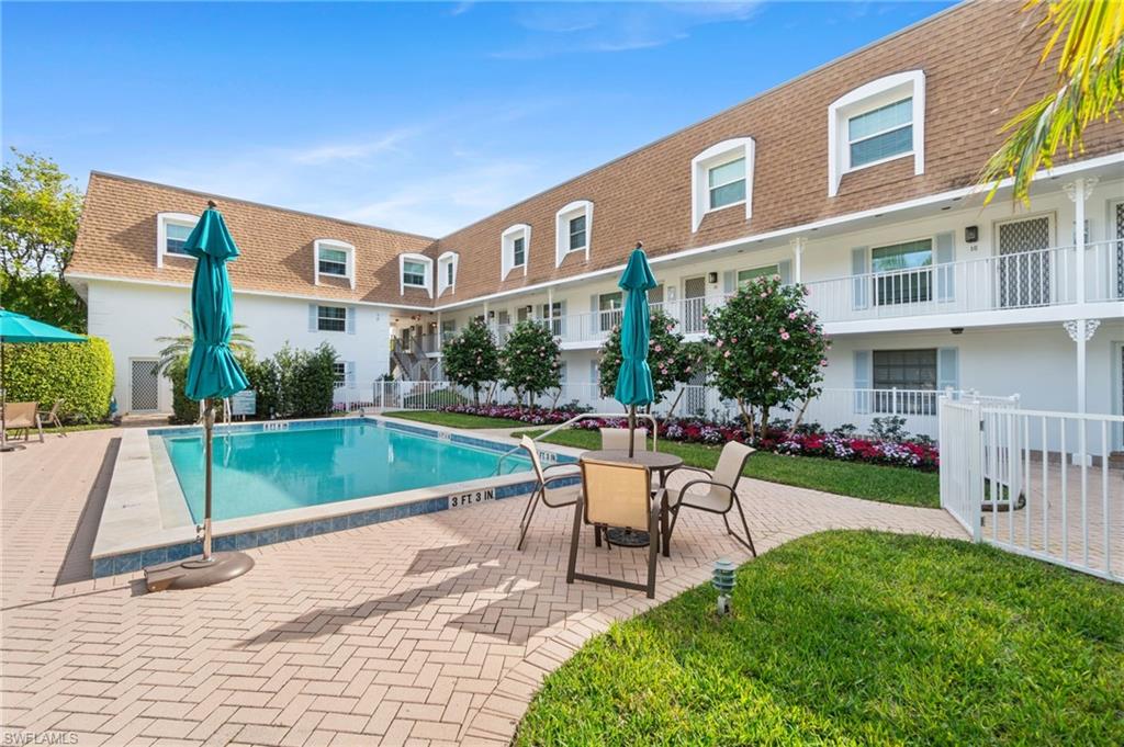Community swimming pool with a brick paver patio surround