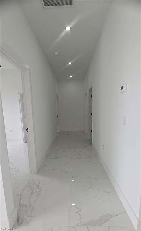 Bright hallway featuring polished tile flooring, recessed lighting, white walls, and white baseboards