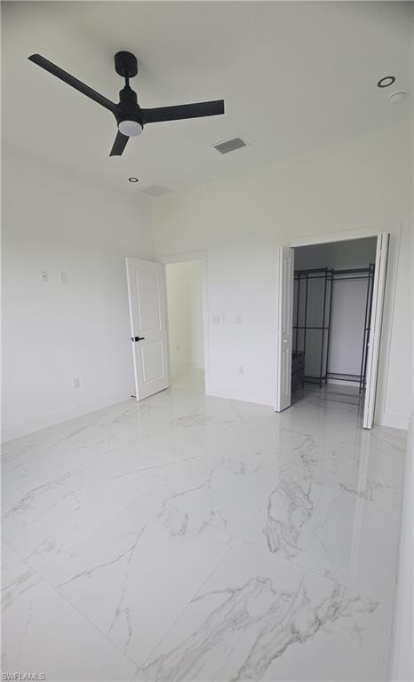 Spacious interior room featuring large format tile flooring, a modern black ceiling fan, and recessed lighting