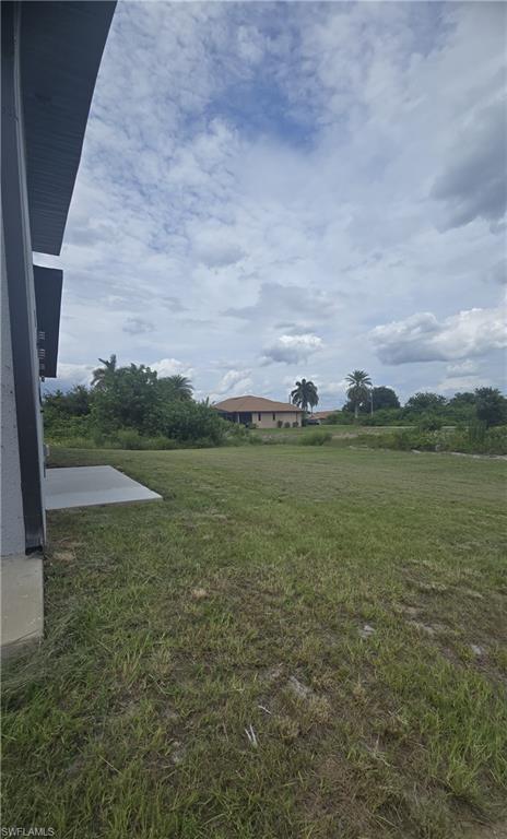 Expansive grassy yard with a concrete patio