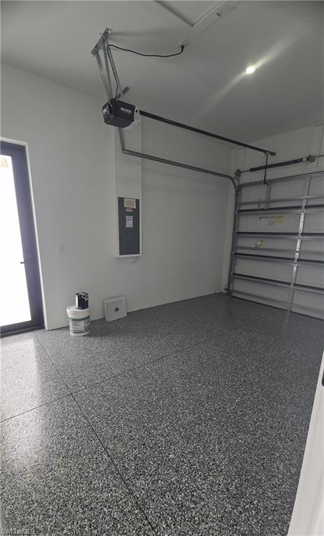 Spacious garage with an epoxy-coated flooring, a paneled garage door, and an automatic garage door opener