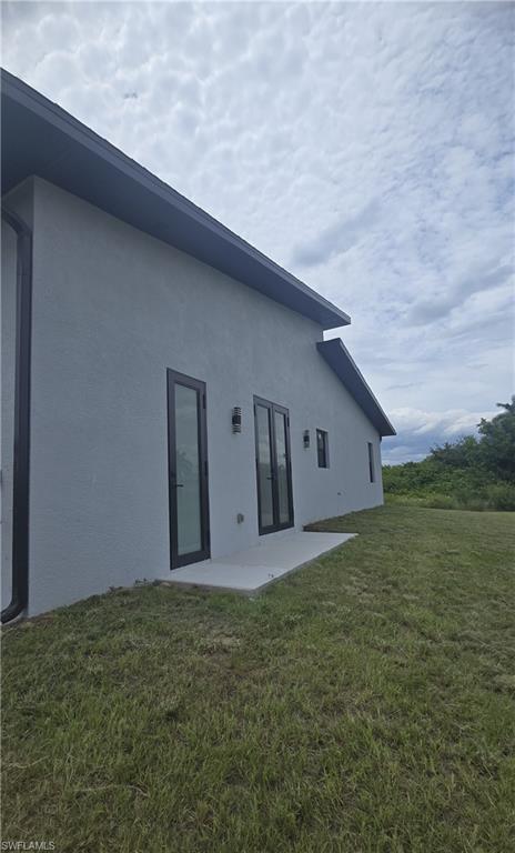 Modern exterior with light gray stucco finish and black trim