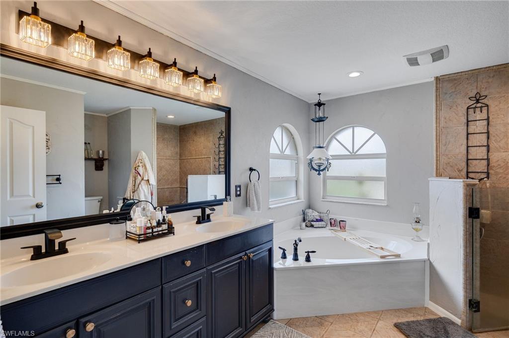Owners suite complete with two sinks, soaking tub and walk in shower with private commode area.