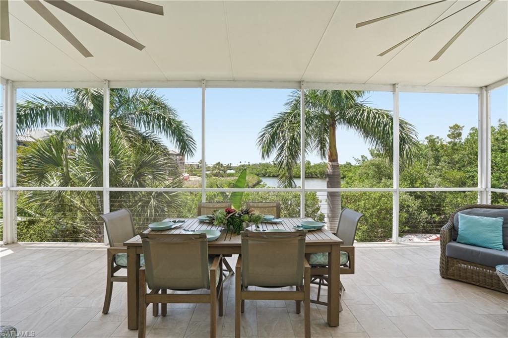 Screened outdoor living area with light-toned tile flooring, white frame enclosure, and a ceiling-mounted fan - Virtually Edited Image