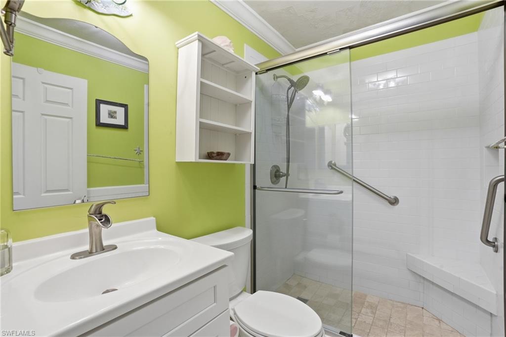 Bathroom featuring a white vanity with a single basin sink, brushed nickel faucet, and a large wall-mounted mirror - Virtually Edited Image