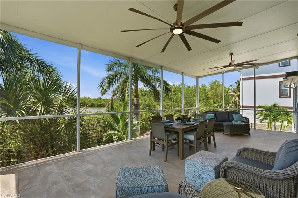 Expansive screened lanai with tile flooring and multiple ceiling fans - Virtually Edited Image