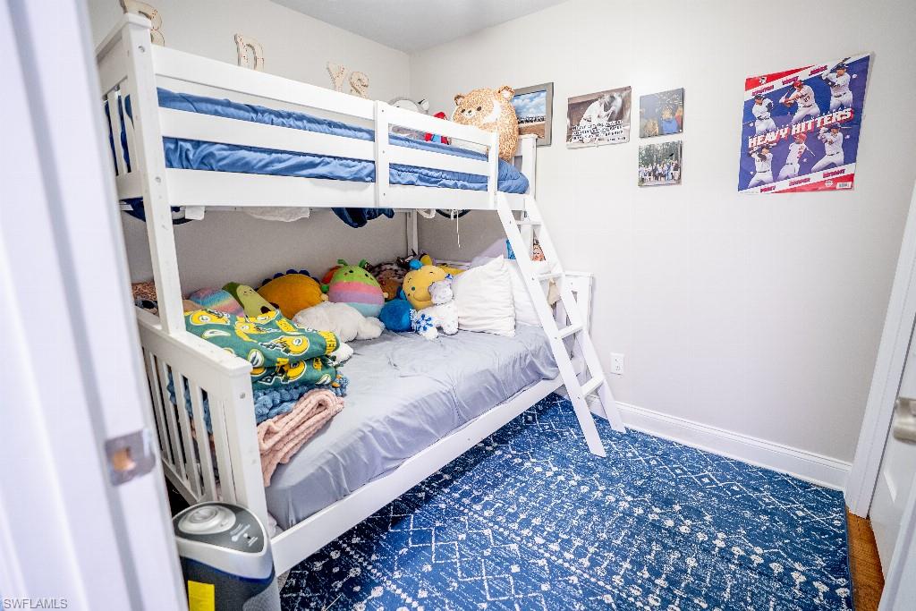 Room featuring white walls, white trim, and wood-finish flooring