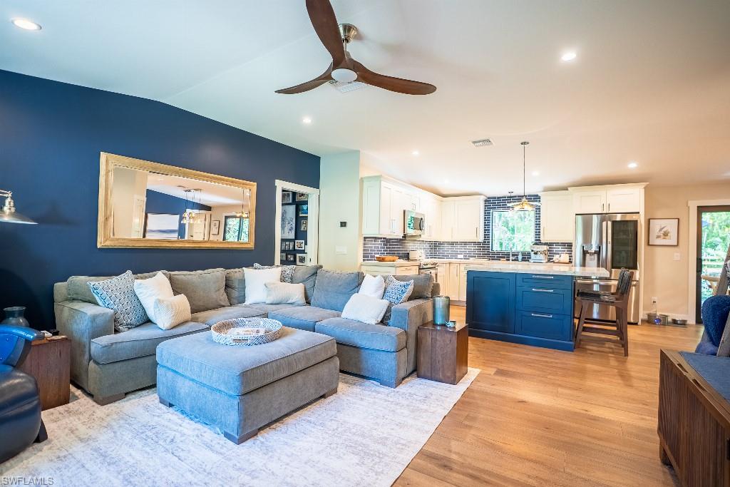 Open-concept living area featuring wood-finish flooring, recessed lighting, and a ceiling fan