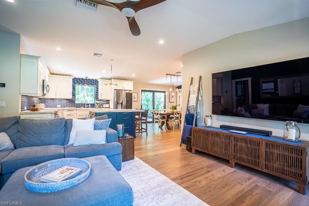 Open-concept living area featuring wood-finish flooring, recessed lighting, and a ceiling fan