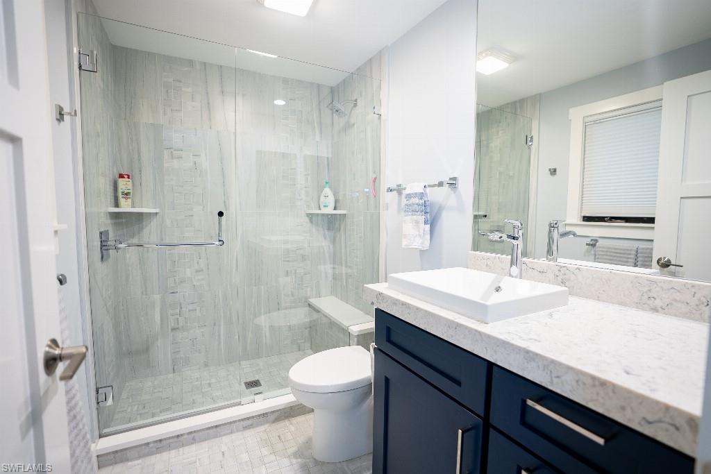 Modern bathroom featuring a frameless glass shower enclosure with full-height tile surround and an integrated bench